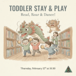 A whimsical illustration for a "Toddler Stay & Play" event. In the center, three young children run and play tambourines between library bookshelves. They are accompanied by a large, friendly green dragon and a small, fuzzy brown monster. A librarian stands in the background, smiling and clapping. The text reads: "Toddler Stay & Play: Read, Roar & Dance! Thursday, February 12th at 10:30."